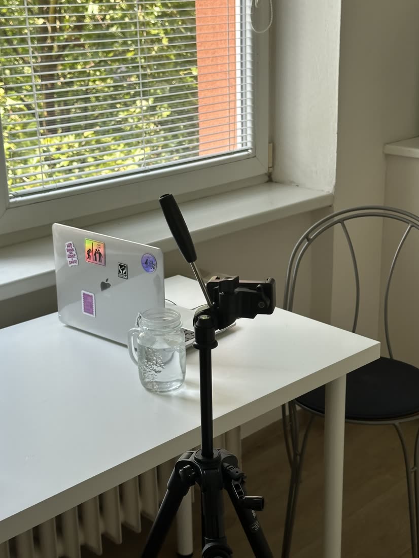 Natáčecí setup u okna s notebookem a telefonem na stativu